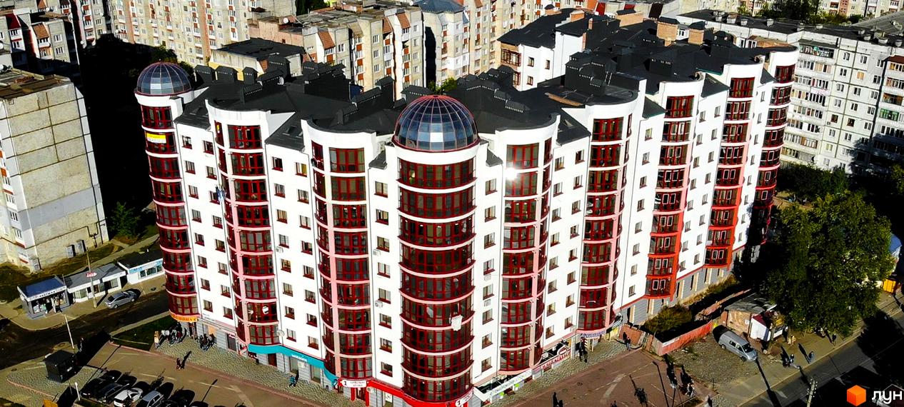Фотографія фасаду Житлового комплексу Red House II з куполами на даху. Навколо будинку видно припарковані автомобілі та пішохідну зону.