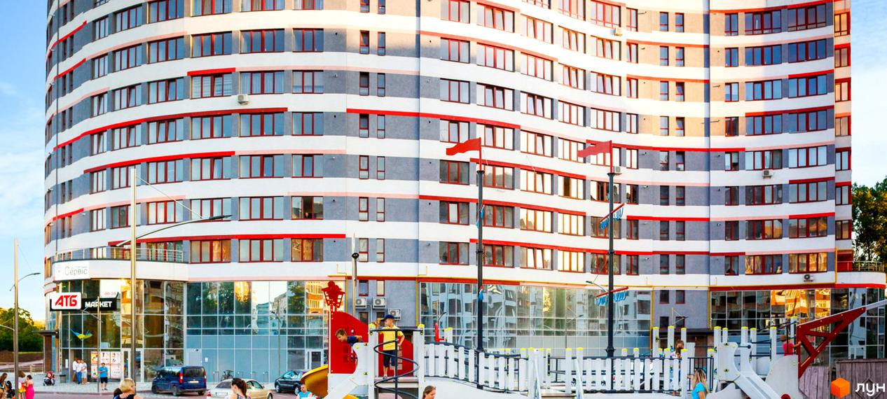 Зображення фасаду багатоповерхового будинку в Житловому комплексі River Park. На передньому плані дитячий майданчик.