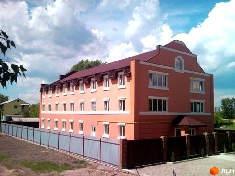 Житловий комплекс на вул. Райдужна, 54, з фасадом пастельного кольору та прибудинковою територією з парканом.