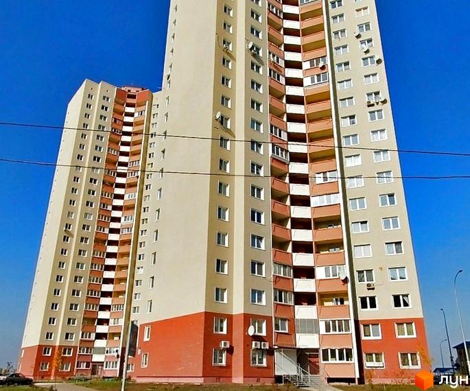 Житловий комплекс на вул. Милославська, 8, 12 з фасадом світлого кольору та балконами. В прибудинковій території є зелена зона та зручний під'їзд.