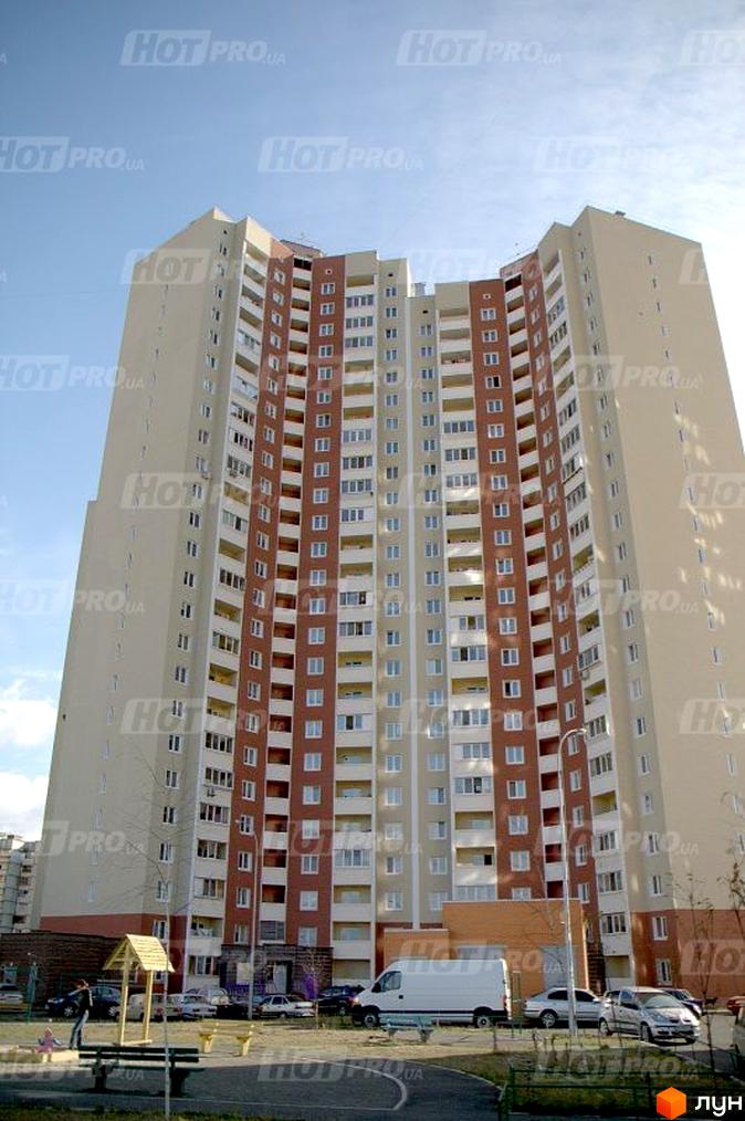 Житловий комплекс на вул. Милославська, 8, 12 з фасадом у світлих кольорах. Прибудинкова територія з дитячим майданчиком та паркомісцями.