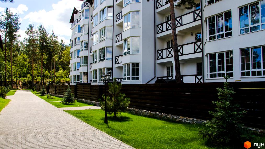 Житловий комплекс DESNA residence: біла багатоповерхівка з численними вікнами та балконами, оточена зеленню та доріжкою.