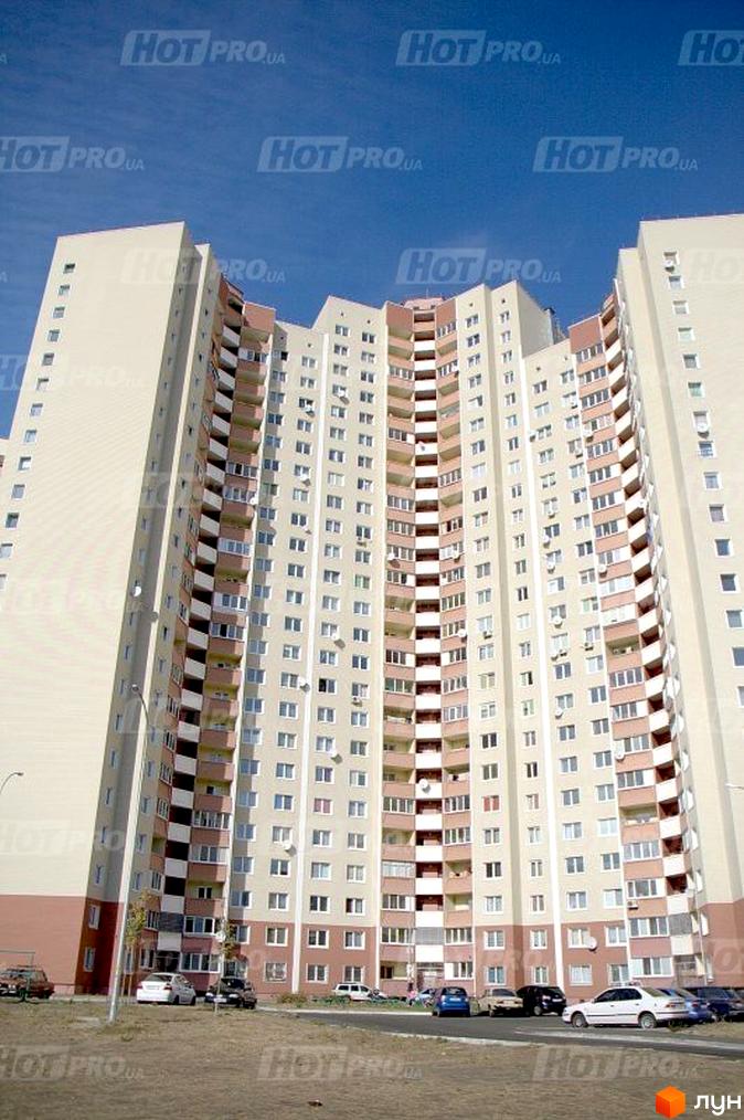 Житловий комплекс на вул. Милославська, 8, 12. Вид на фасад будинку з парковкою та прибудинковою територією.