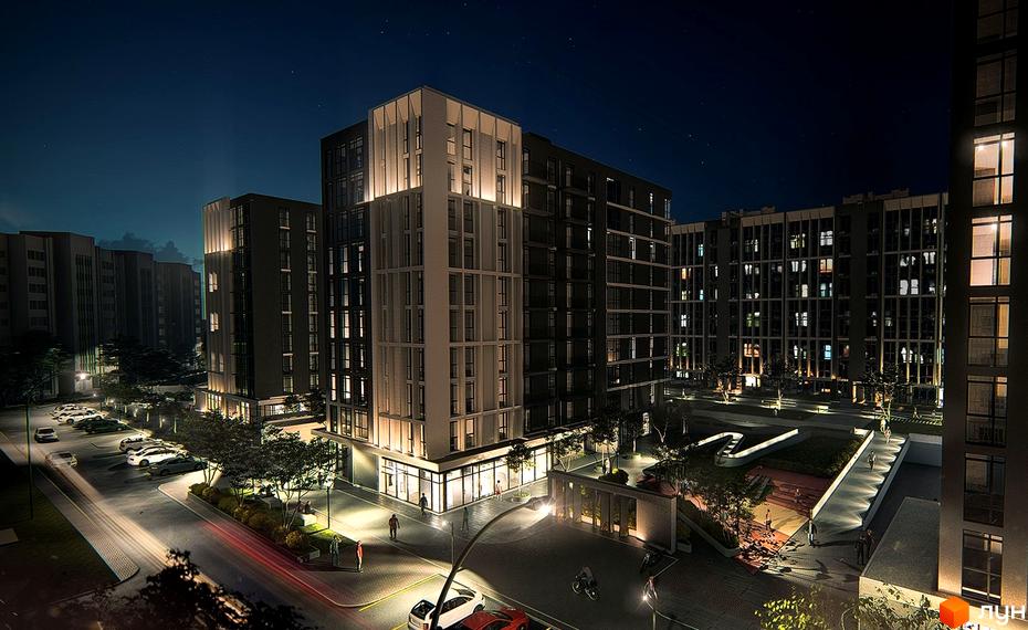 Житловий комплекс Panorama вночі: освітлені будівлі з великими вікнами, парковка з автомобілями, доглянута прибудинкова територія з деревами та пішохідними доріжками.