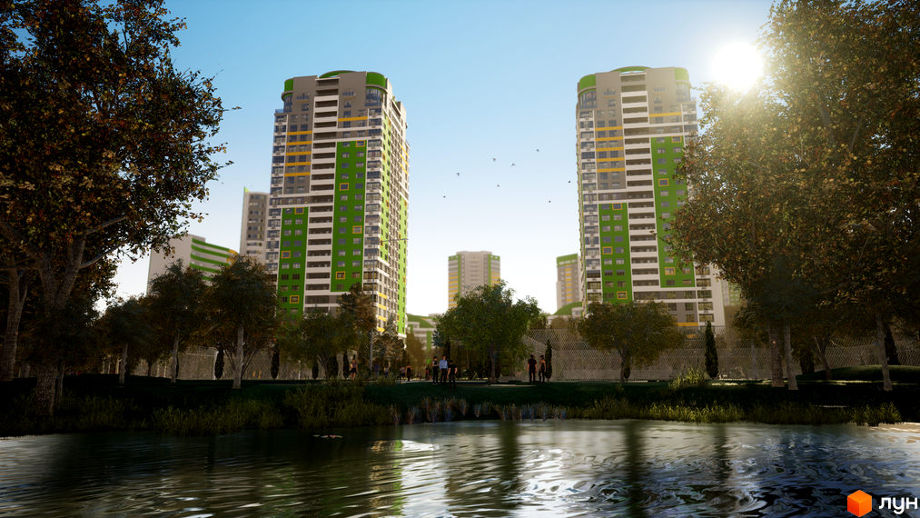 Житловий комплекс Паркове місто з високими будинками, що мають зелені та сірі фасади. Перед будинками розташований парк з водоймою, деревами та людьми, що прогулюються.