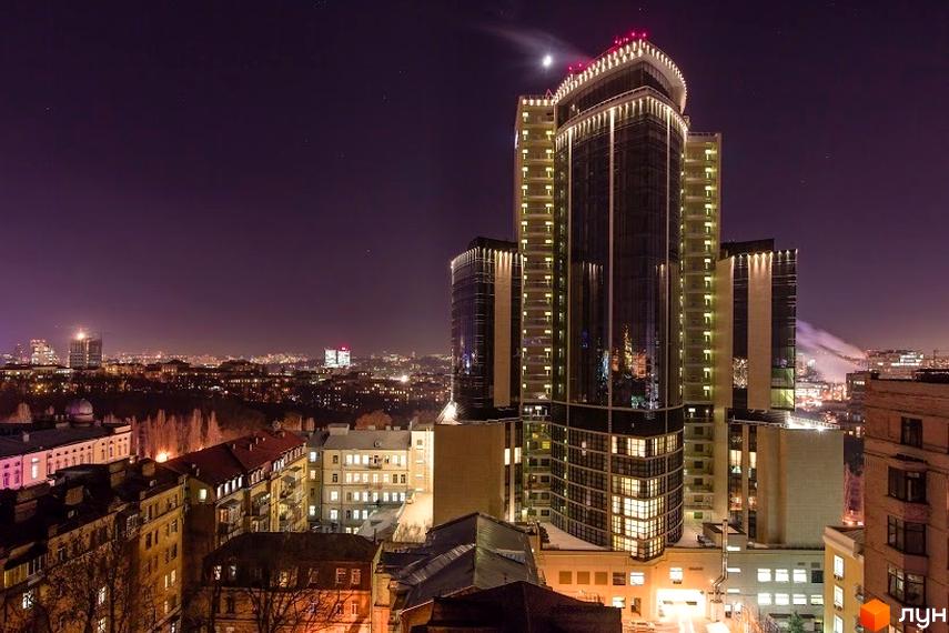 Житловий комплекс ARCH House на фоні нічного міста. Вид на сучасну архітектуру та прибудинкову територію.