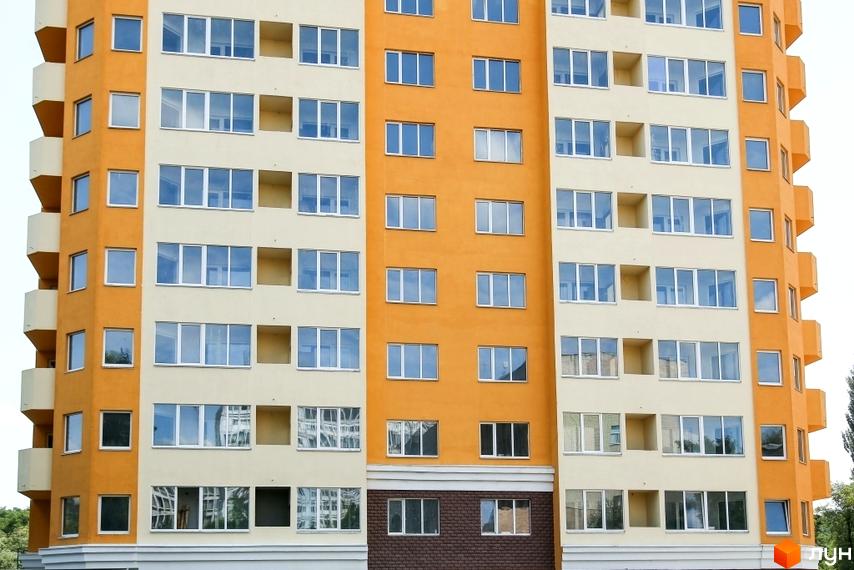 Багатоповерховий будинок житлового комплексу Solo Park з великою кількістю вікон та балконами. Фасад будівлі пофарбований у світлі та жовті кольори.