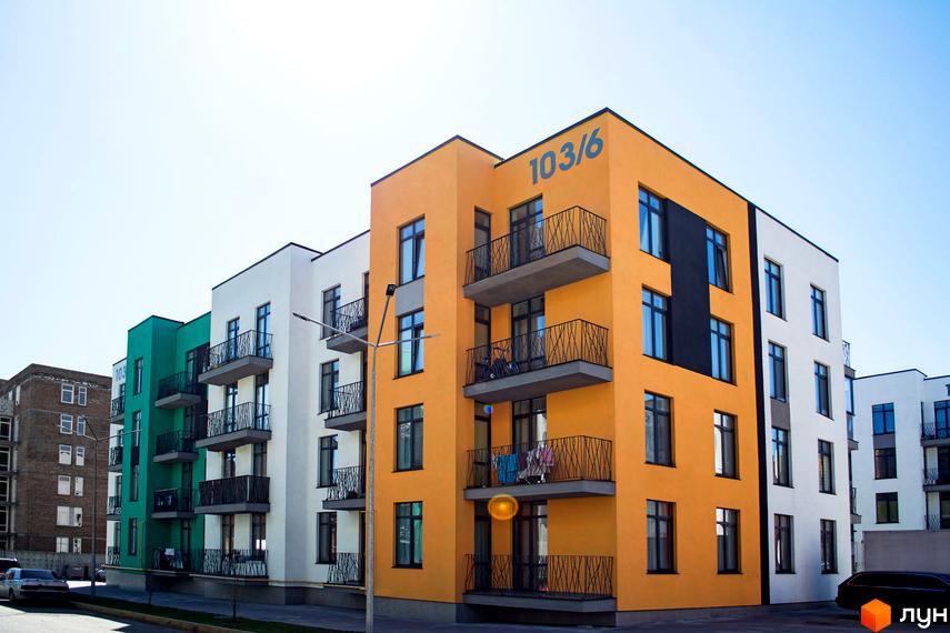 Яскраві фасади житлового комплексу Європейка з балконами та вікнами. Будинки розташовані вздовж дороги з автомобілями.