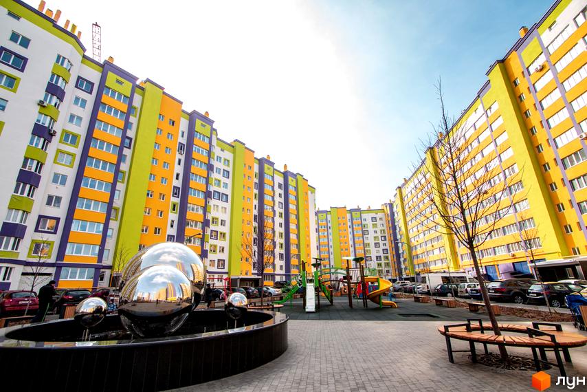 Житловий комплекс Щасливий на Яблуневій. Яскраві фасади будинків, дитячий майданчик та зона відпочинку.