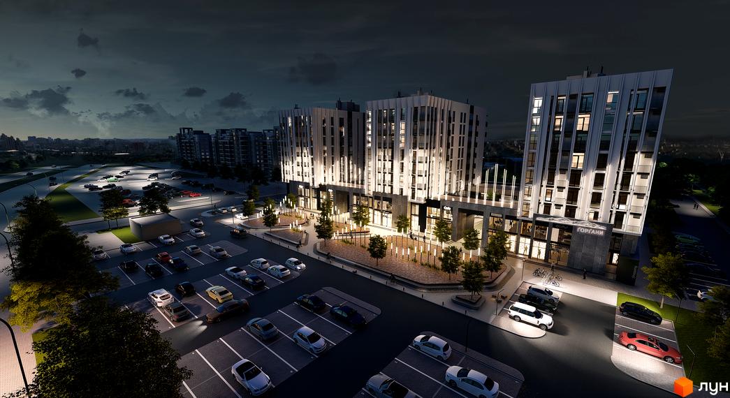 Зовнішній вигляд новобудови ЖК Ґорґани вночі з підсвіткою фасаду та парковкою з автомобілями. Опис комплексу та прибудинкової території.