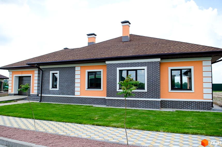 Зовнішній вигляд будинку житлового комплексу КМ Green Town з яскравими стінами та зеленим газоном. Прибудинкова територія з плиткою та молодими деревами.