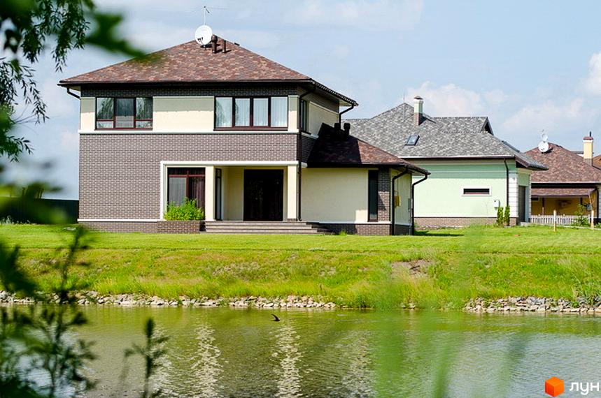 Котеджне містечко КМ Green Town. Двоповерхові будинки з цегляним та світлим фасадом, розташовані біля водойми на зеленій ділянці.