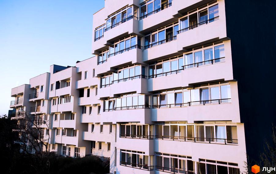 Новобудова ЖК Панорама з численними вікнами та балконами. Будинок має білий фасад та розташований на тлі блакитного неба.