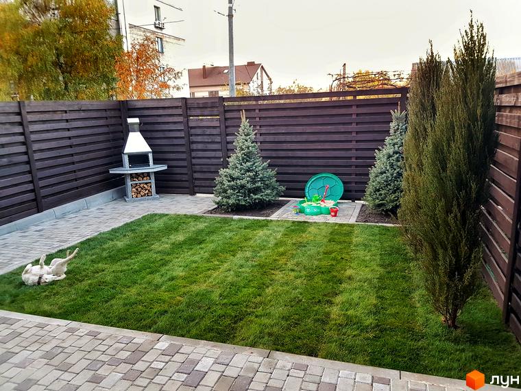 Затишний двір з барбекю та дитячим майданчиком біля таунхаусів 