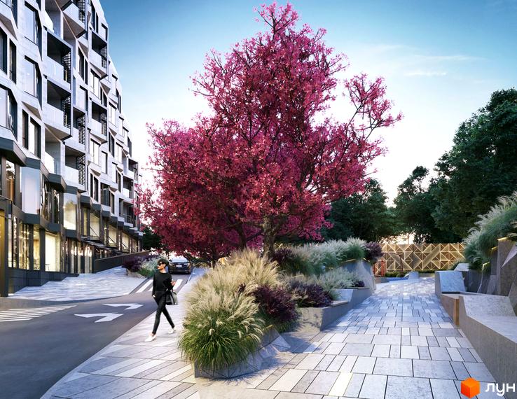 Зображення фасаду будинку в Житловому комплексі Fjord. На передньому плані рожеве дерево та пішохідна зона з ландшафтним дизайном.