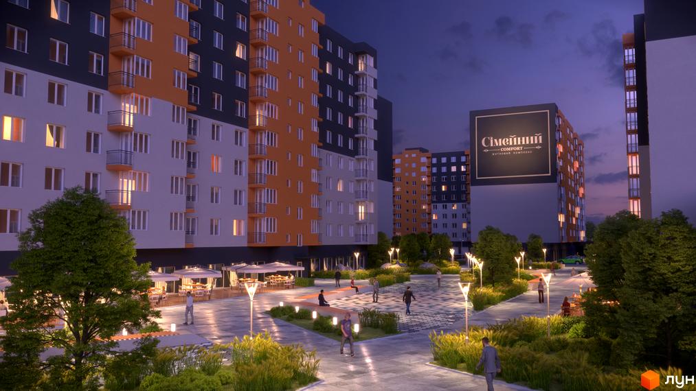 Житловий комплекс Сімейний COMFORT з багатоповерховими будинками та фасадами в оранжевих і сірих тонах. Прибудинкова територія освітлена ліхтарями.