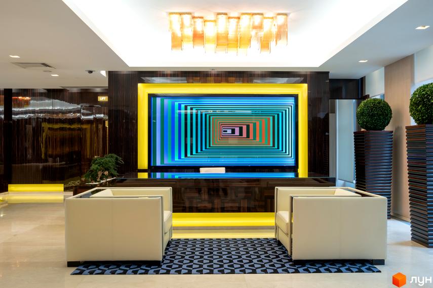 Сучасний інтер'єр рецепції житлового комплексу Cascade Plaza з диванами та декоративними рослинами.