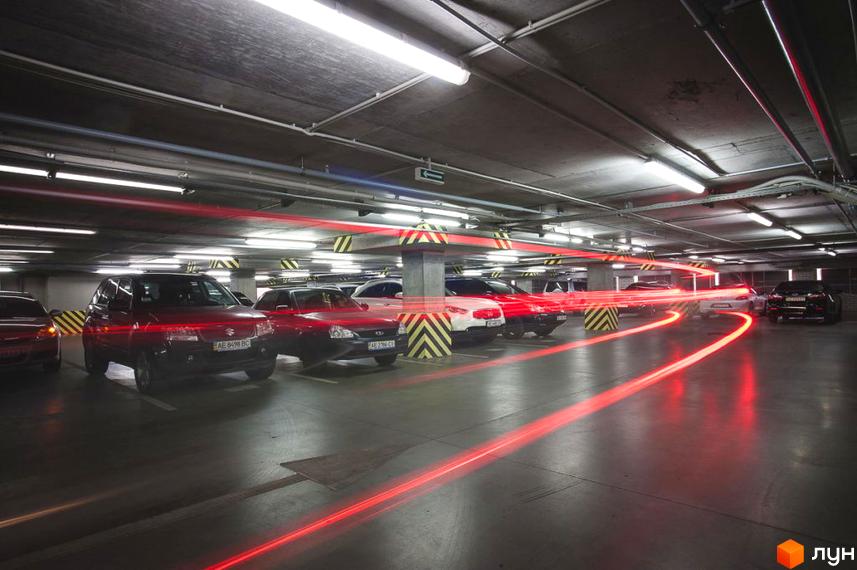 Паркінг житлового комплексу Cascade Plaza з автомобілями. Простора територія з освітленням та безпечними розмітками.