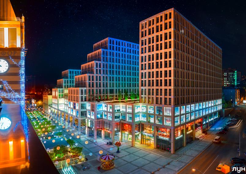 Житловий комплекс Cascade Plaza з сучасними фасадами та прибудинковою територією, освітленою вечірніми вогнями.