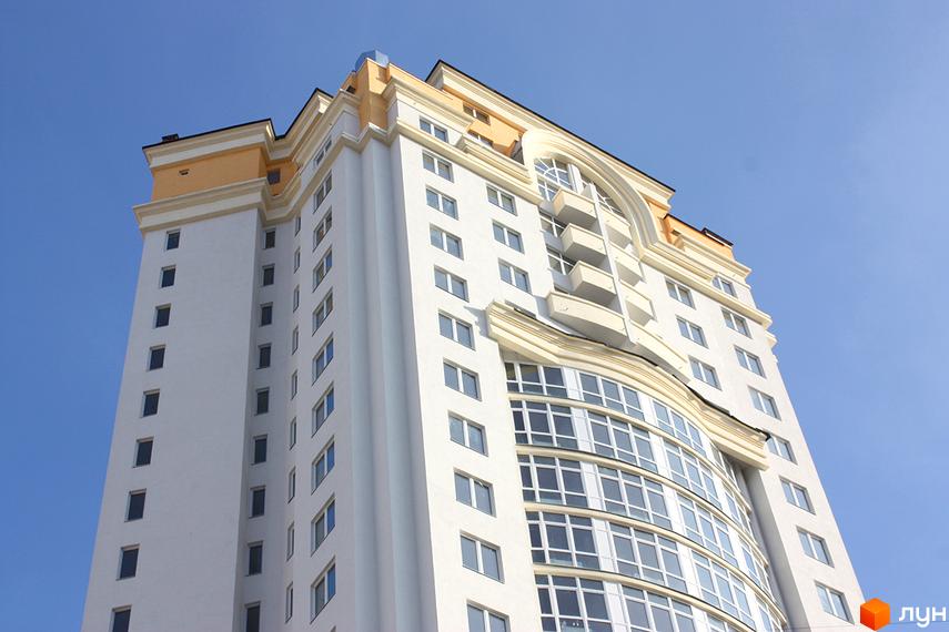 Фото фасаду багатоповерхового будинку ЖК Obolon Tower. Вигляд з низу на висотну новобудову з великими вікнами.