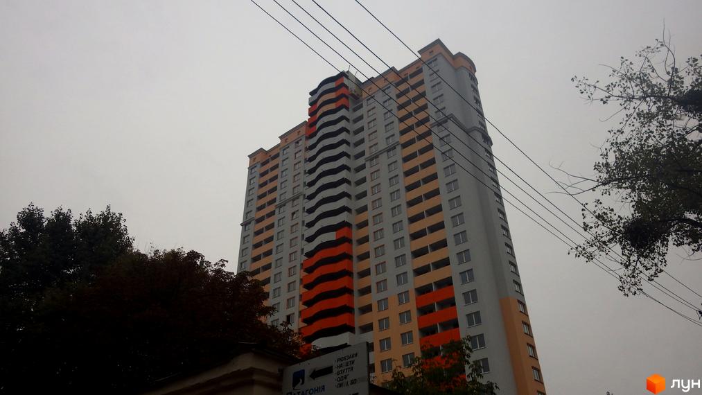 Фото багатоповерхового будинку по вул. Юрія Поправки (Миколи Лебедєва), 14. Житловий комплекс з великою кількістю вікон та оригінальним дизайном фасаду.