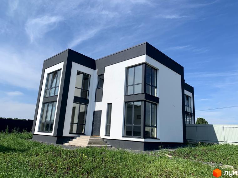 Котеджне містечко КМ Tivoli: двоповерховий будинок з білою та чорною обробкою, великими вікнами та зеленою прибудинковою територією.