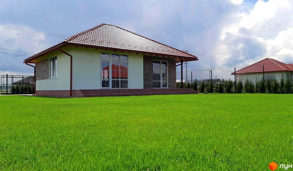 Котеджне містечко Green Kvartal: одноповерховий будинок з червоною черепичною покрівлею, цегляним та світлим фасадом, розташований на доглянутій зеленій галявині.