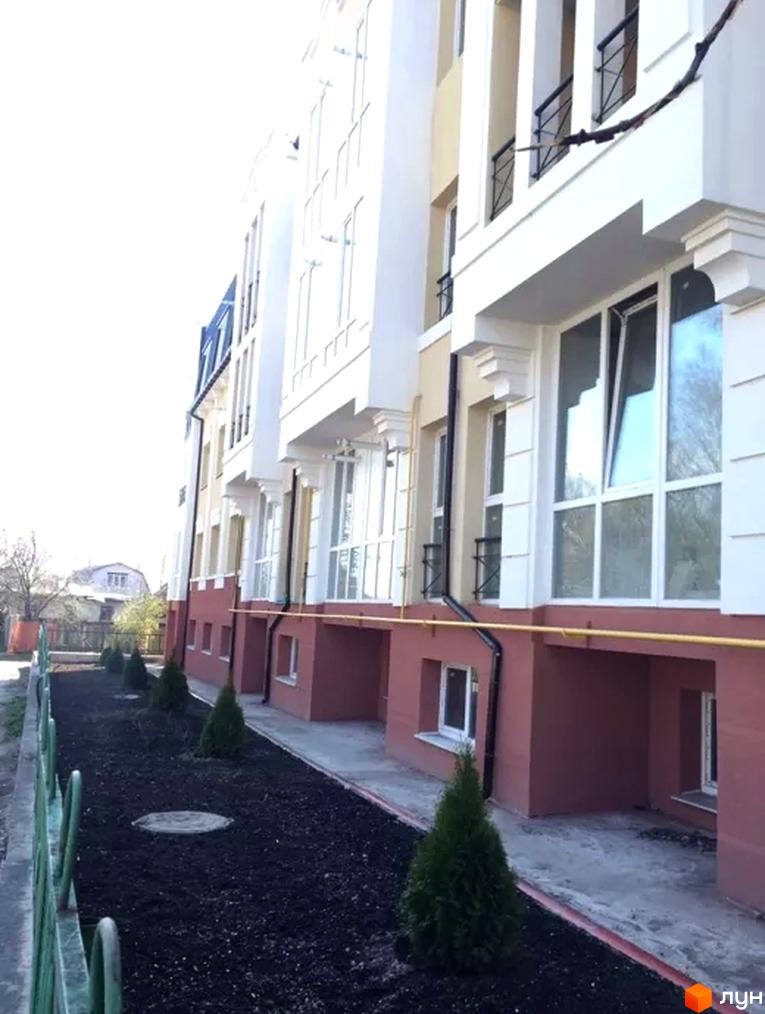 Фасад житлового комплексу на вул. Князя Чорного, 4а, з прибудинковою територією та зеленими насадженнями.