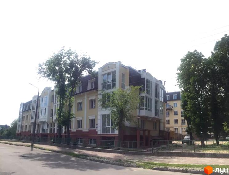 Фасад житлового комплексу на вулиці Князя Чорного, 4а, з елементами декору та балконами. Перед будинком розташована прибудинкова територія з деревами та дорогою.