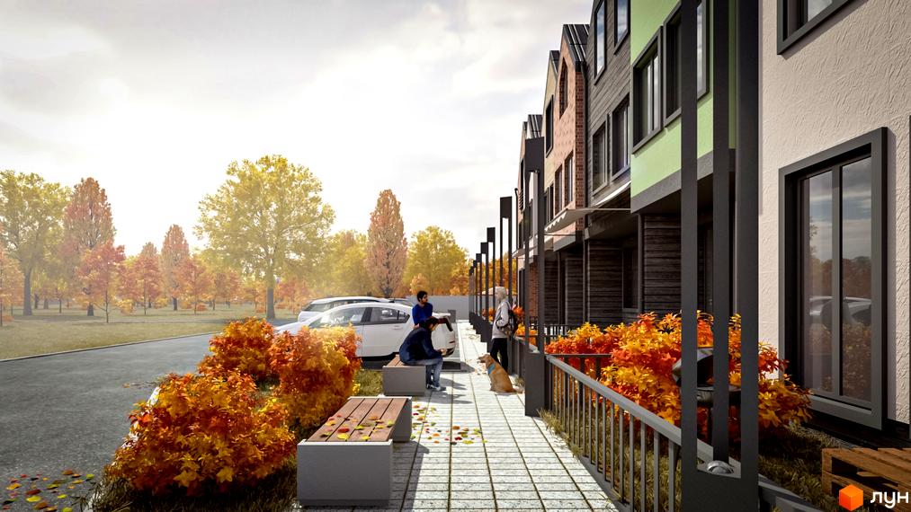 Таунхауси New Smart 4 з різнокольоровими фасадами. Прибудинкова територія з осінніми кущами, доріжкою та парковкою, на задньому плані осінній парк.