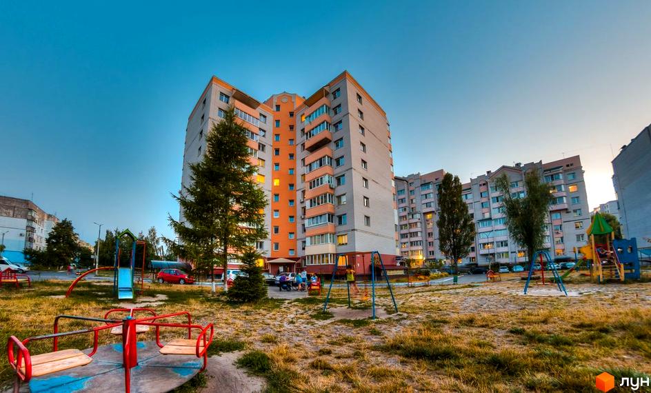 Зовнішній вигляд житлового комплексу на вул. Вокзальна, 49. На прибудинковій території розташований дитячий майданчик з гіркою та гойдалками.