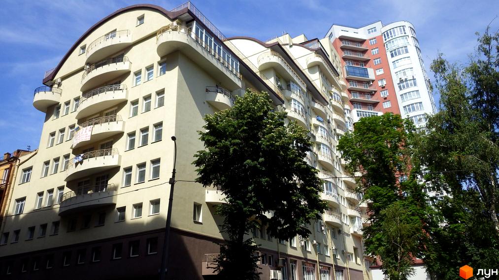 Житловий комплекс на вулиці Тургенєвська, 46/11. Будинок має вигнутий фасад з численними балконами та великими вікнами. Навколо будівлі ростуть дерева.