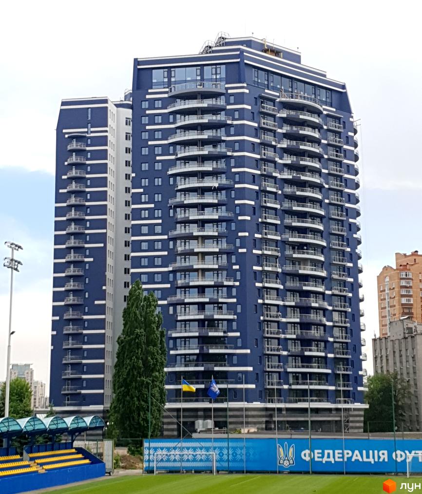 Житловий комплекс Alter Ego – це висотна синя будівля з численними балконами та великими вікнами. Навколо комплексу розташовані спортивні об'єкти та зелені насадження.