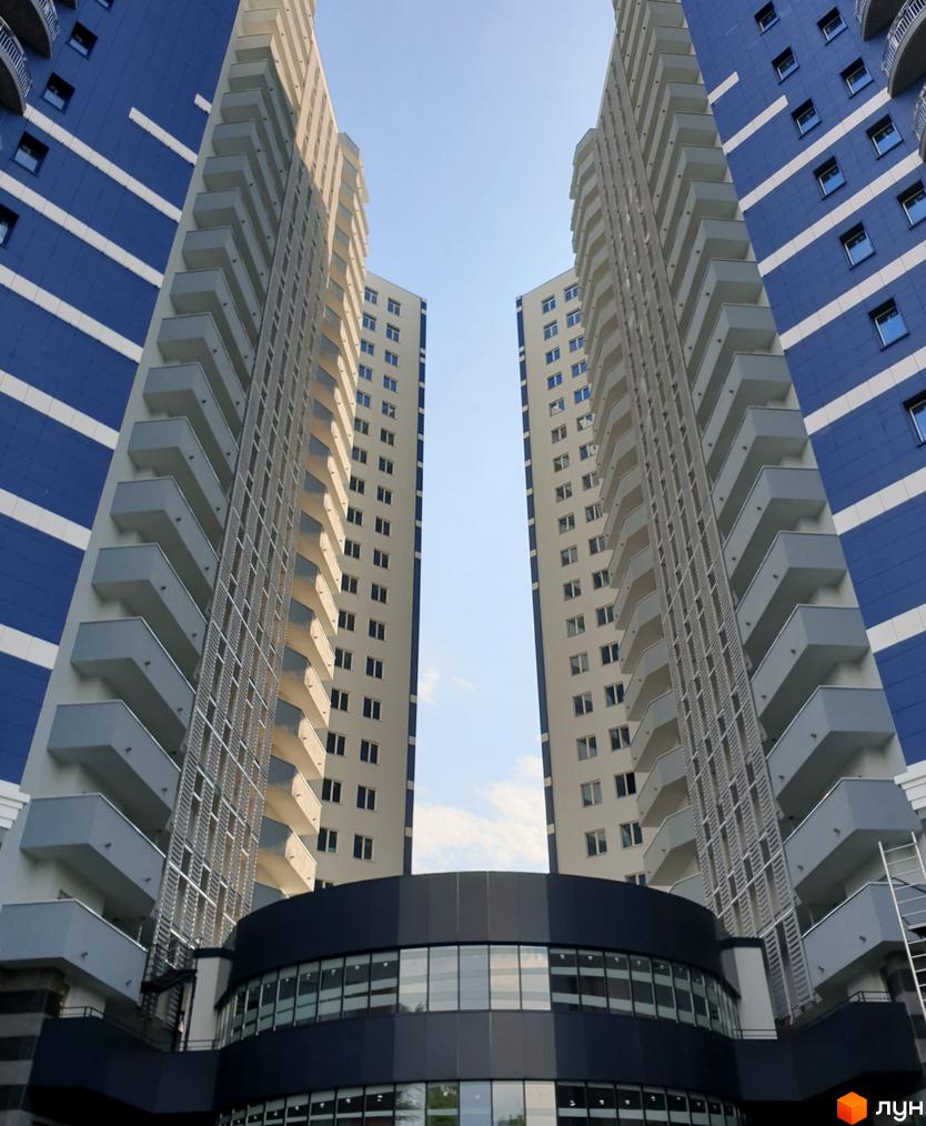 Житловий комплекс Alter Ego. Зовнішній вигляд висотних будинків з балконами та синьо-білими фасадами.