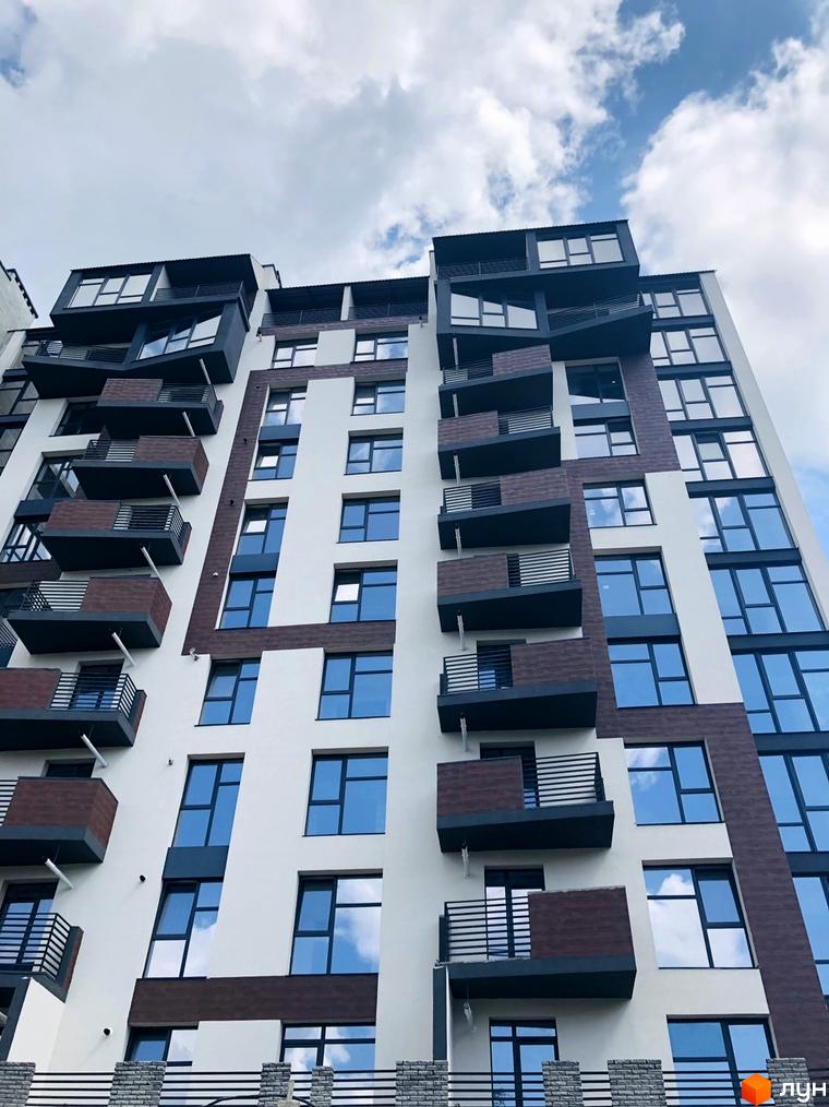 Зовнішній вигляд будинку ЖК Перлина Проскурова з численними балконами та великими вікнами. Будівельний проєкт з сучасною архітектурою.