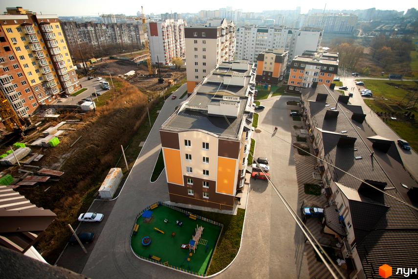 Візуалізація житлового комплексу Срібні Озера Комфорт з різнокольоровими фасадами та дитячим майданчиком на прибудинковій території.