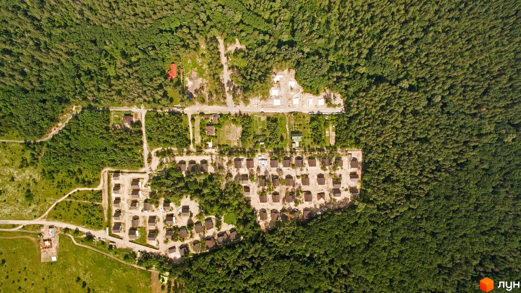 Котеджне містечко КМ Ліс та Озеро: вид згори на однотипні будинки з коричневими дахами та прибудинкову територію з зеленими насадженнями та доріжками.