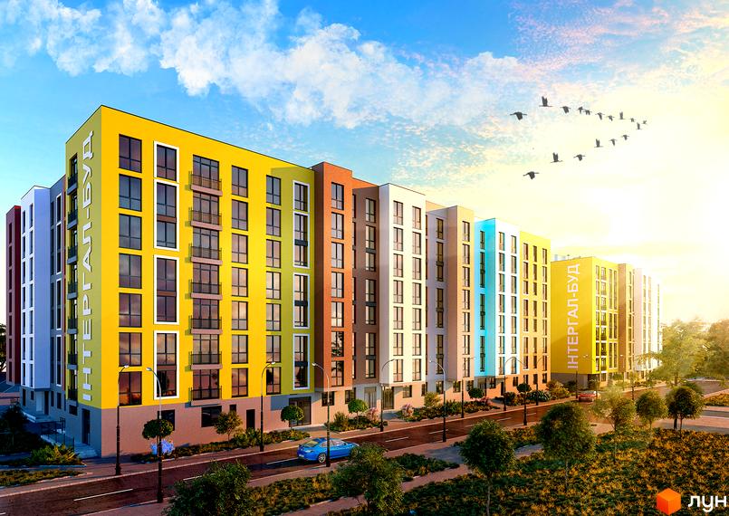 Яскравий багатоповерховий будинок з різнокольоровими фасадами. На території ЖК Київський є зелені насадження та дорога з автомобілями.