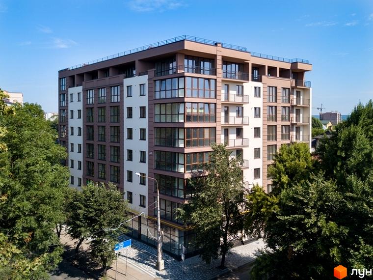 Зовнішній вигляд житлового комплексу Central House з великою кількістю скляних елементів та балконами. Навколо комплексу ростуть зелені дерева, а на передньому плані видно частину дороги та тротуару.