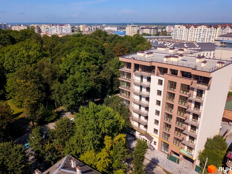 Житловий комплекс Central House – це сучасна багатоповерхова будівля з балконами та великими вікнами, оточена зеленню та іншими міськими будівлями.