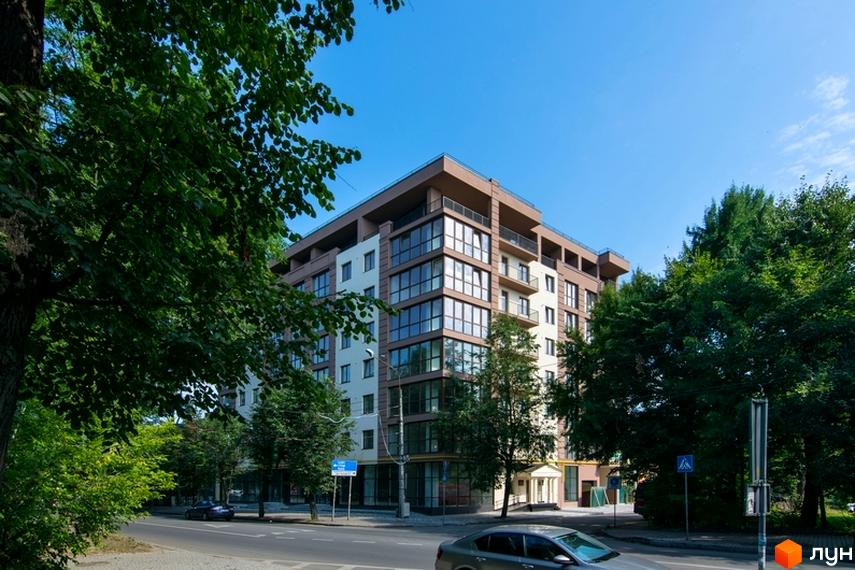 Житловий комплекс Central House - це багатоповерхова новобудова з панорамними вікнами та балконами, розташована на фоні зелених дерев та блакитного неба.