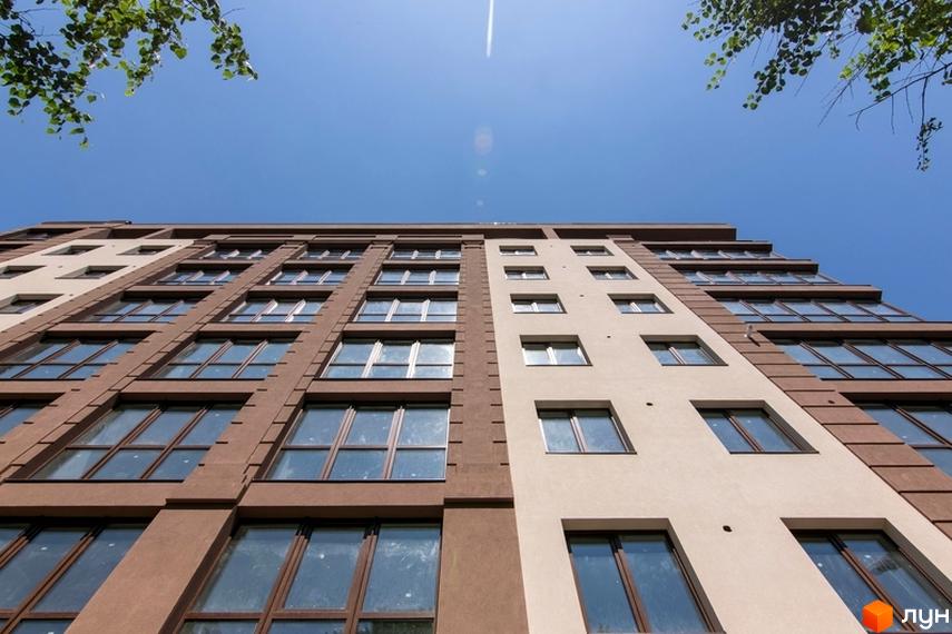 Зовнішній вигляд новобудови ЖК Central House з коричневими та світлими фасадами, великою кількістю вікон та блакитним небом.