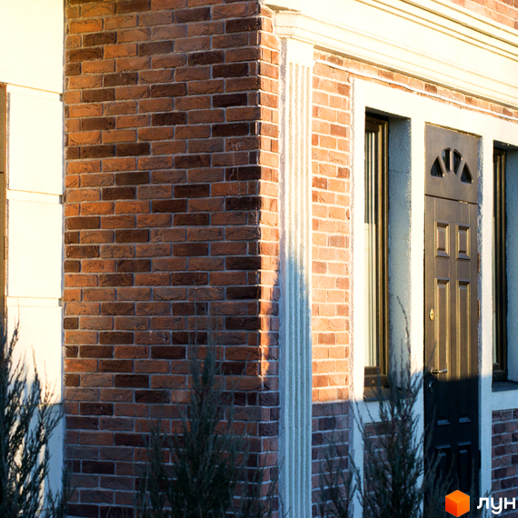 Фасад житлового комплексу Liverpool House з цегляною кладкою та дверима. Зовнішній вигляд новобудови з елементами класичного дизайну.