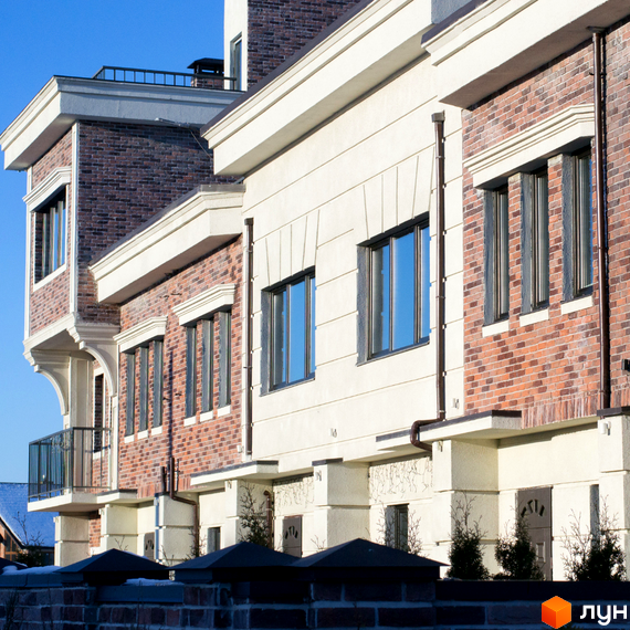 Фасад житлового комплексу Liverpool House з цегляними та світлими елементами. Навколо будівель видно зелені насадження та паркан.