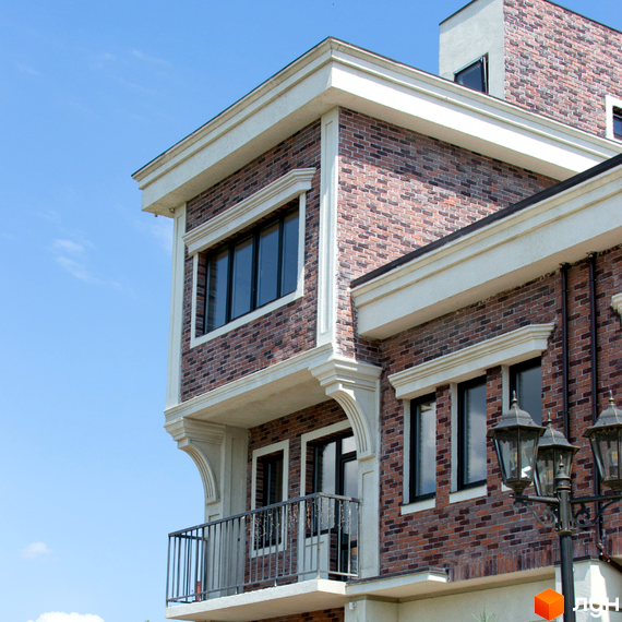 Фасад таунхаусів Liverpool House з цегляним оздобленням та великими вікнами. Балкон з кованими перилами на тлі блакитного неба.