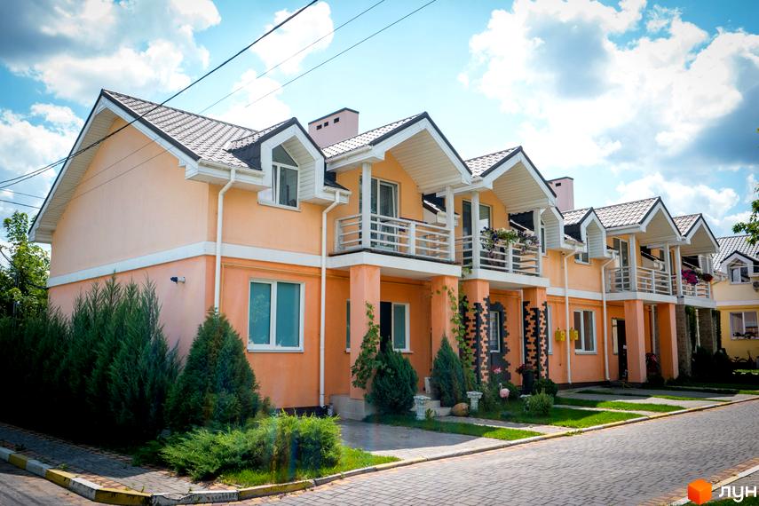 Зовнішній вигляд Котеджного містечка Sun City. Двоповерхові будинки з балконами та зеленими насадженнями на прибудинковій території.