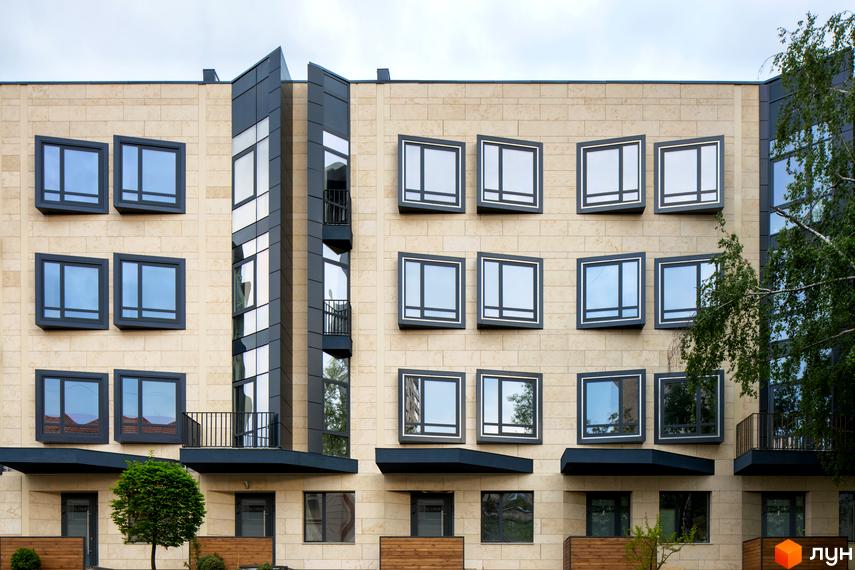 Фасад житлового комплексу Struetinsky з великою кількістю вікон та балконів. Перед будинком розташоване дерево та зелені насадження.