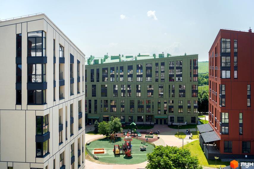 Житловий комплекс Spectrum: фасади будівель в бежевих та зелених тонах, дитячий майданчик та зелена зона відпочинку.