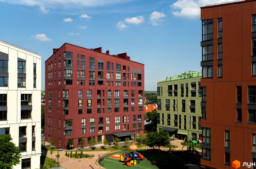 Комплекс Spectrum: фасади будівель червоного, зеленого та білого кольорів. Прибудинкова територія з дитячим майданчиком та зеленими насадженнями.