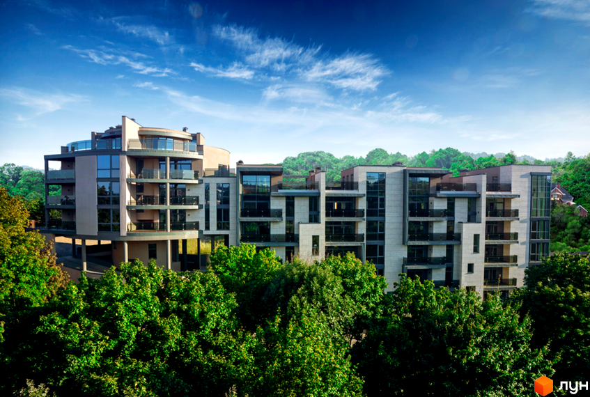 Житловий комплекс Pechersk Hills Residence з панорамними вікнами та балконами, розташований серед зелені дерев. Архітектура з використанням світлих фасадів та великих вікон.